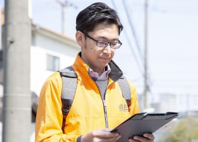 資料を手に訪問する男性スタッフ