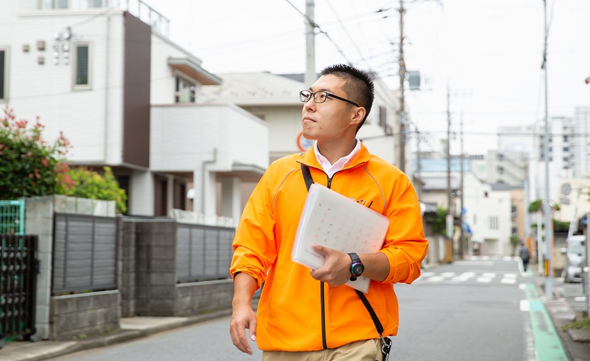 資料を手に訪問する男性スタッフ